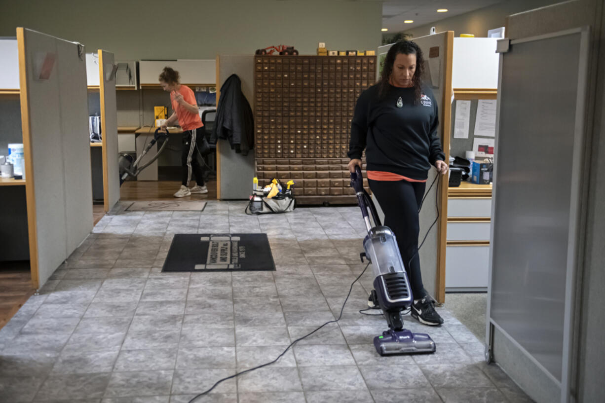 Shannon Eagen-Anderson, background left, and Jahnea Lecouris of Couve Cleaning tackle a cleaning job Jan. 12 at Vancouver Bolt &amp; Supply.