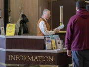 Volunteer Gene Waid, left, lends a hand at the first-floor information desk of the Clark County Courthouse while directing people to where they need to go at the local justice hub on a recent Friday morning. After more than a decade doing a variety of jobs at the courthouse, Waid has become familiar with the myriad things that bring people to the downtown complex.