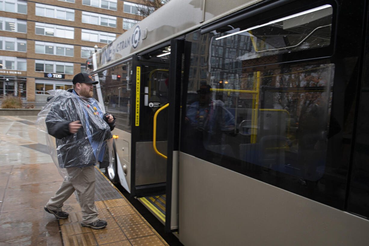 Passenger Timothy Sadlier II is prepared for the elements as he boards a C-Tran Red Vine bus at Turtle Place Station.