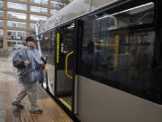 Passenger Timothy Sadlier II is prepared for the elements as he boards a C-Tran Red Vine bus at Turtle Place Station.