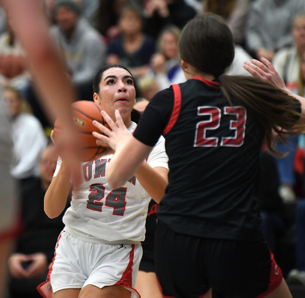 Union senior Ava Smith, left, eyes the basket Tuesday, Jan. 2, 2024, during the Titans’ 65-43 loss to Camas at Union High School.