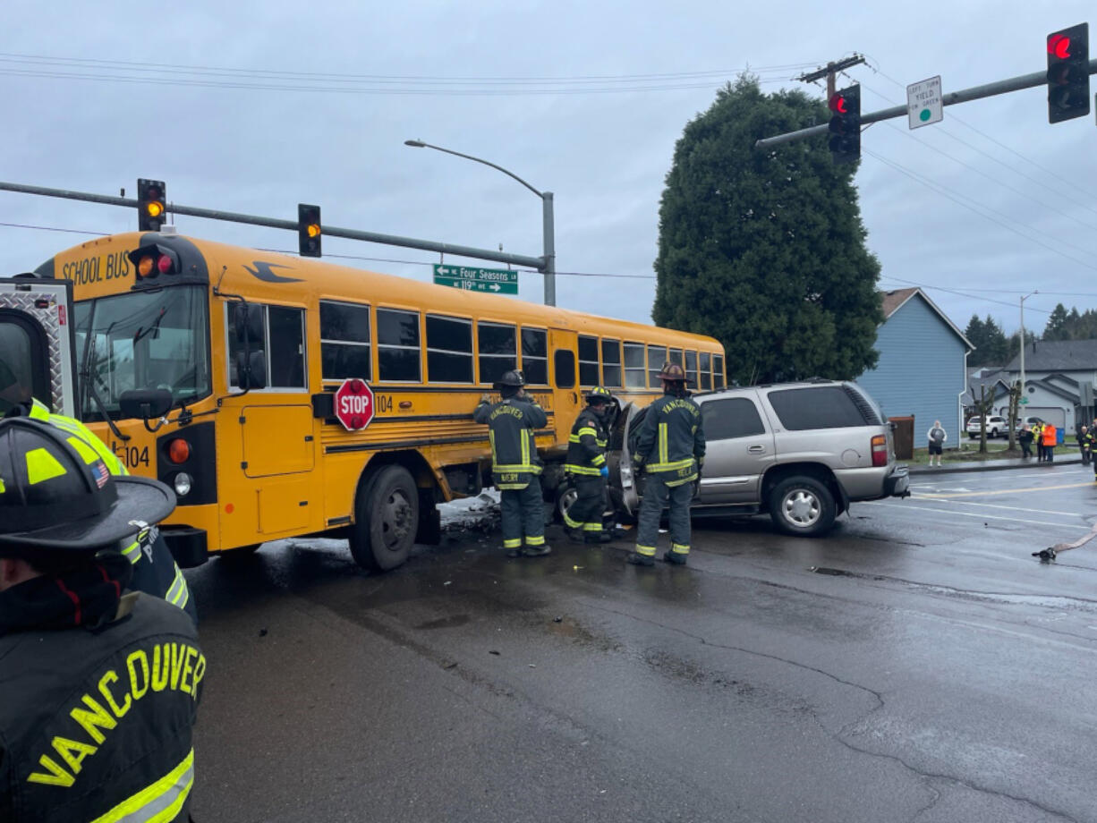Firefighters from the Vancouver Fire Department respond to a collision between an SUV and school bus Wednesday morning in the Image neighborhood. Four people, including three students, were treated for minor injuries.
