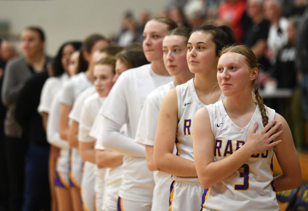 Columbia River junior Marley Myers, right, and the rest of the team stand during the national anthem Friday, Jan. 5, 2024, during the Rapids’ 43-33 win against Ridgefield at Columbia River High School.