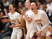 Columbia River junior Kaya Mirtich, right, and Columbia River junior Brooklyn Moore, left, celebrate with the bench after a basket Friday, Jan. 5, 2024, during the Rapids’ 43-33 win against Ridgefield at Columbia River High School.