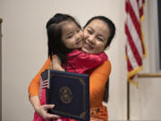 Monica Tran, 3, of Hazel Dell, left, is all smiles while congratulating her mom, Thao Nguyen, who is originally from Vietnam, after she officially became a United States citizen at Washington State University Vancouver on Thursday morning. Nguyen was one of 30 candidates from 19 countries who took part in the naturalization ceremony held in honor of Martin Luther King Jr.