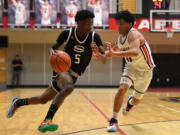 Skyview senior Demaree Collins, left, dribbles against Camas junior Nyima Namru on Tuesday, Jan. 23, 2024, during the Storm’s 69-66 loss to Camas at Camas High School.