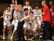 Camas players erupt in celebration around junior Beckett Currie (1) on Tuesday, Jan. 23, 2024, after Currie hit a game-winning three pointer against Skyview at Camas High School. Camas won 69-66.