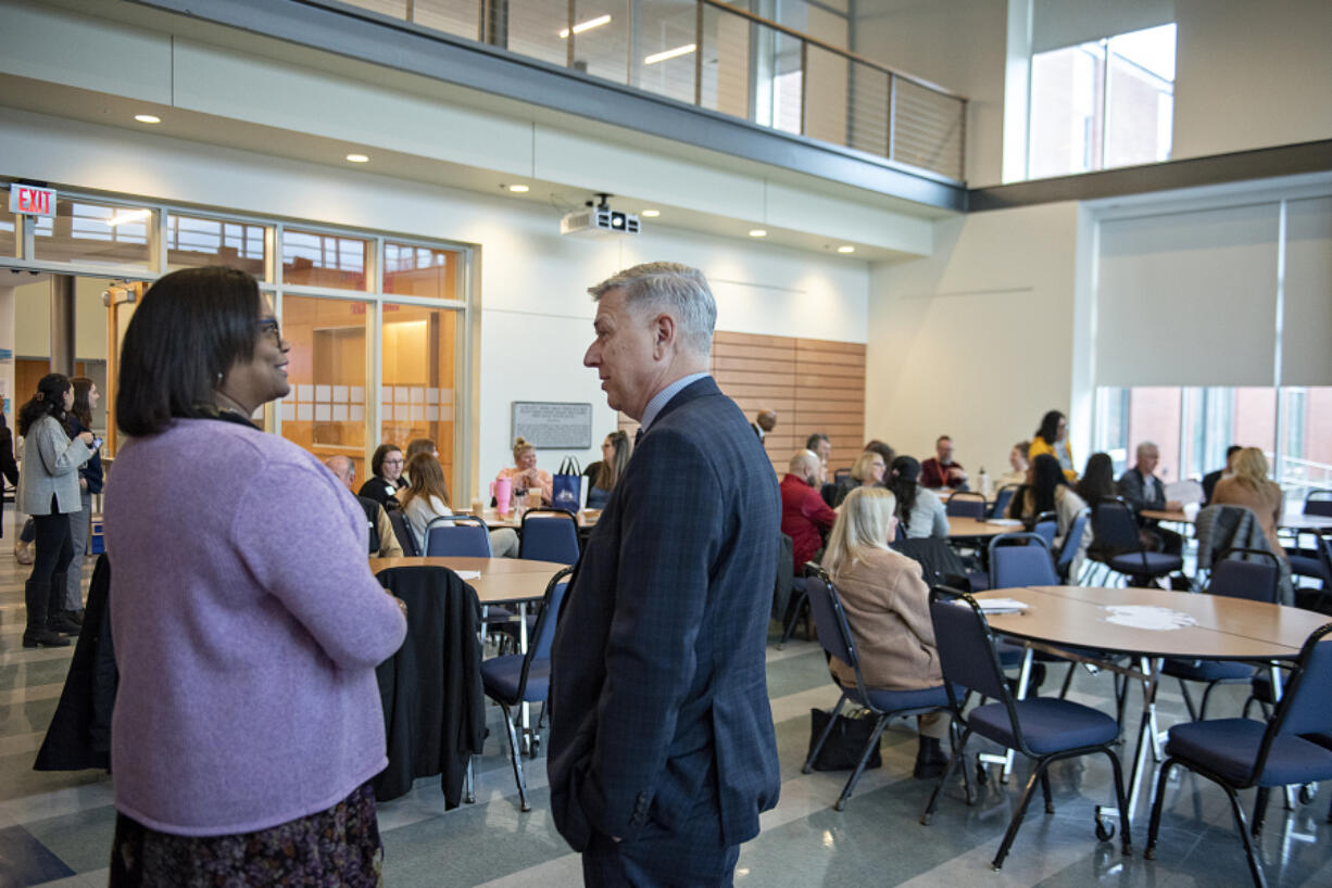 Clark College President Karin Edwards, left, talks with Washington State University Vancouver Chancellor Mel Netzhammer before speaking to the crowd at Clark College on Monday morning.