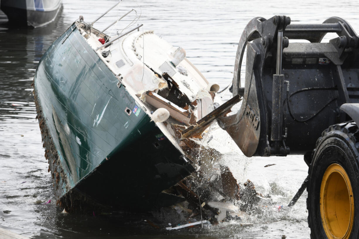 A front-end loader breaks apart a derelict boat from the waters of Oakland Alameda Estuary in Oakland, Calif., on Dec. 21. The Oakland Police Marine unit removed the boats from the shore and towed them to the parking lot of the Jack London Aquatic Center where they were destroyed and loaded into large dump trucks.