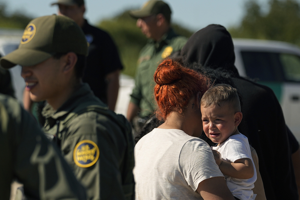 Migrants wait to be processed by the U.S. Customs and Border Patrol after they crossed the Rio Grande and entered the U.S. from Mexico, Thursday, Oct. 19, 2023, in Eagle Pass, Texas. Starting in March, Texas will give police even broader power to arrest migrants while also allowing local judges to order them out of the U.S. under a new law signed by Republican Gov. Greg Abbott.