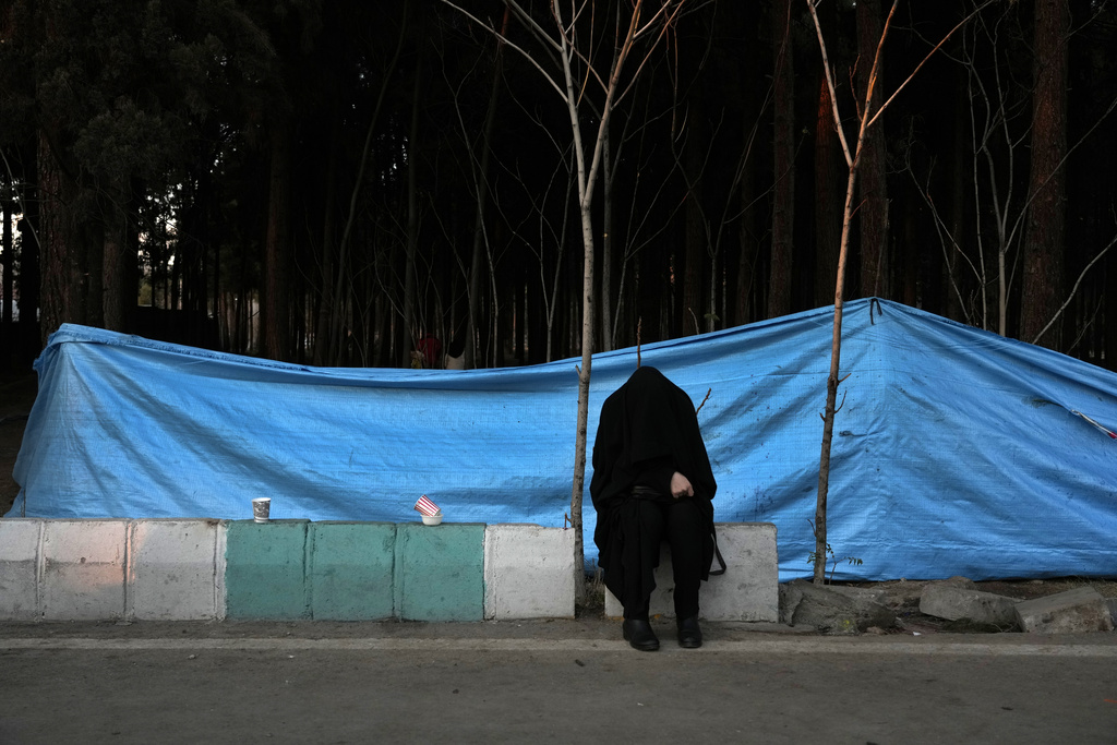 A woman weeps at the scene of  Wednesday's bomb explosion in the city of Kerman about 510 miles (820 kms) southeast of the capital Tehran, Iran, Thursday, Jan. 4, 2024. Investigators believe suicide bombers likely carried out an attack on a commemoration for an Iranian general slain in a 2020 U.S. drone strike, state media reported Thursday, as Iran grappled with its worst mass-casualty attack in decades and as the wider Mideast remains on edge.