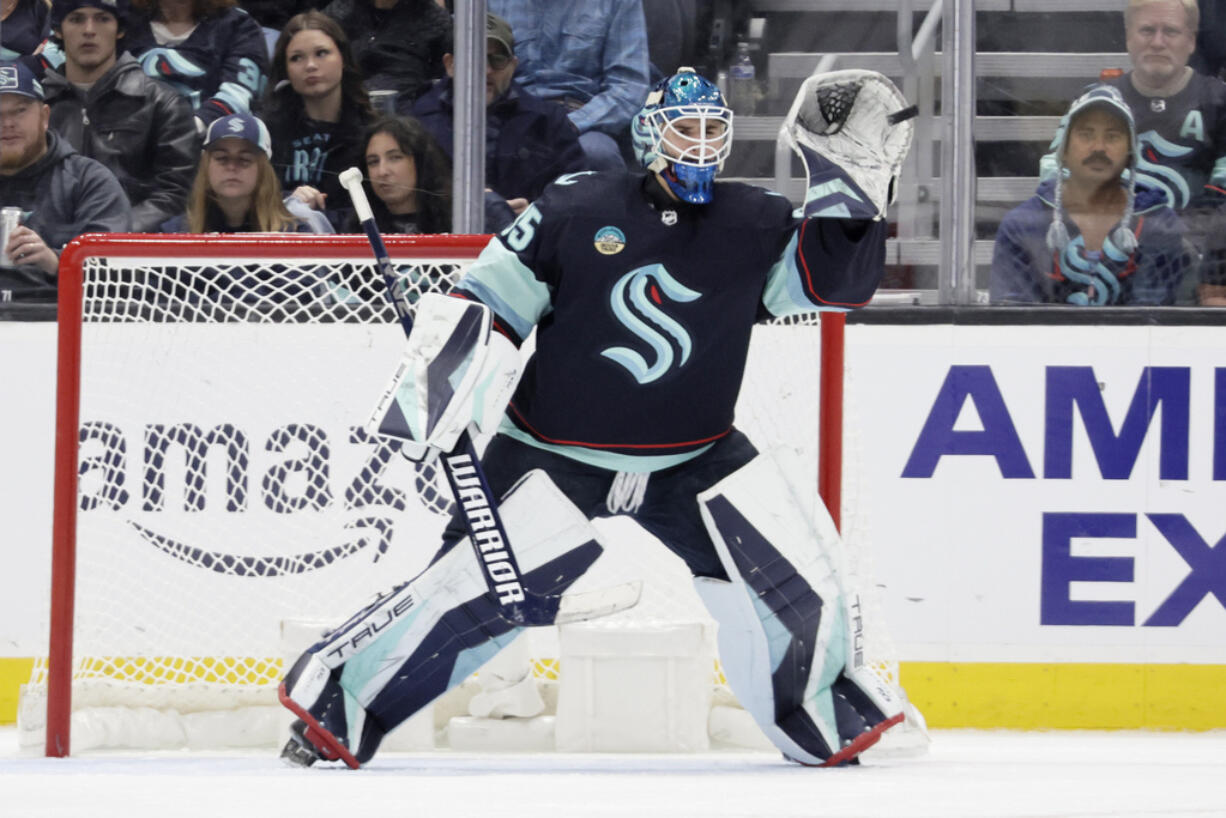 Seattle Kraken goaltender Joey Daccord (35) reaches up to catch a high shot by a Ottawa Senators player during the first period of an NHL hockey game, Thursday, Jan. 4, 2024, in Seattle.