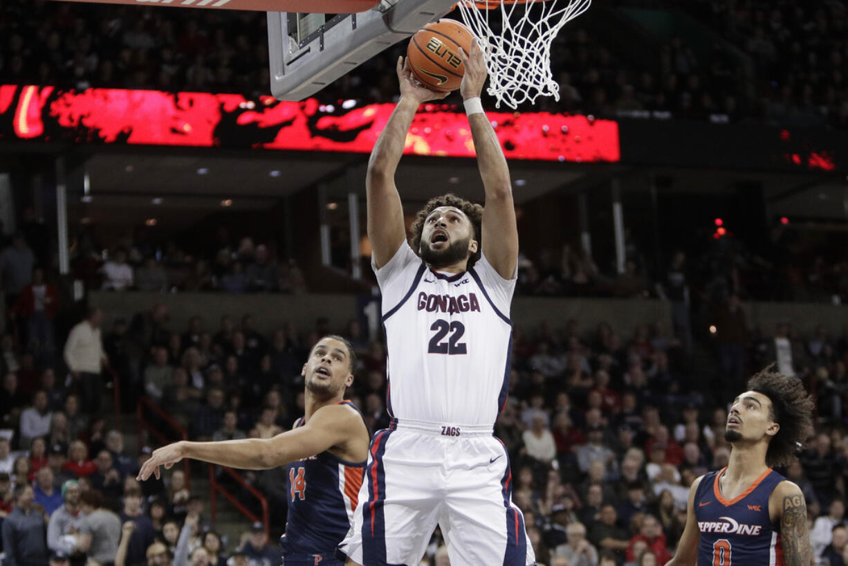 Gonzaga forward Anton Watson (22) shoots next to Pepperdine forward Jevon Porter, left, during the second half of an NCAA college basketball game Thursday, Jan. 4, 2024, in Spokane, Wash.