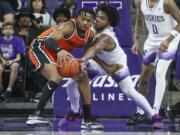 Oregon State guard Dexter Akanno, left, fends off Washington Huskies guard Sahvir Wheeler during the first half of an NCAA college basketball game Saturday, Jan. 6, 2024, in Seattle.