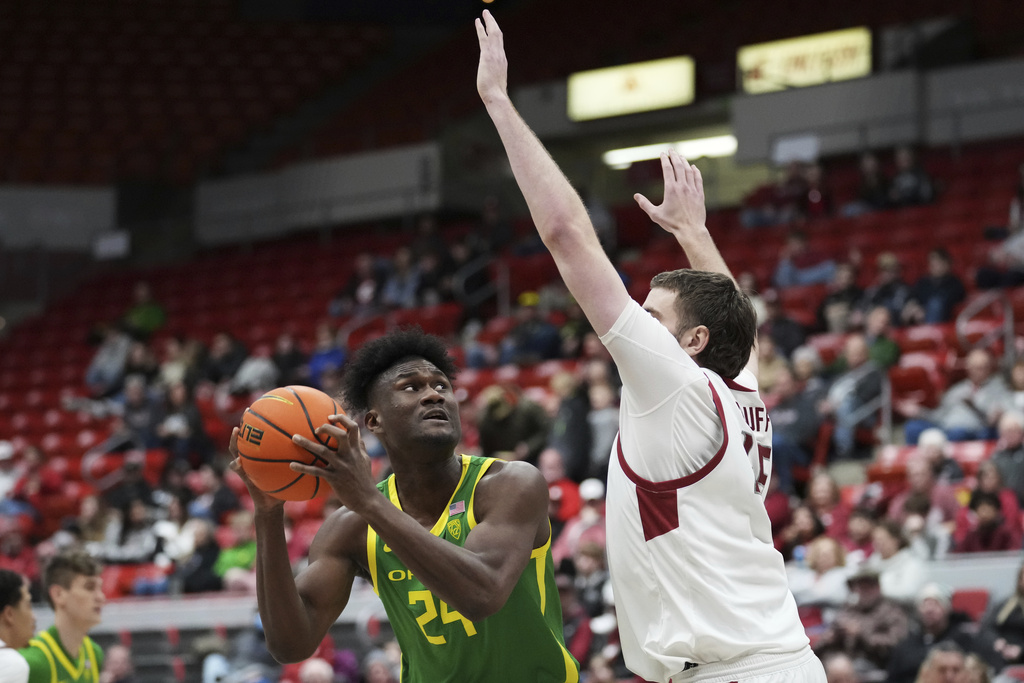 Oregon center Mahamadou Diawara (24) looks to shoot past Washington State forward Oscar Cluff during the first half of an NCAA college basketball game Saturday, Jan. 6, 2024, in Pullman, Wash. (AP Photo/Ted S.