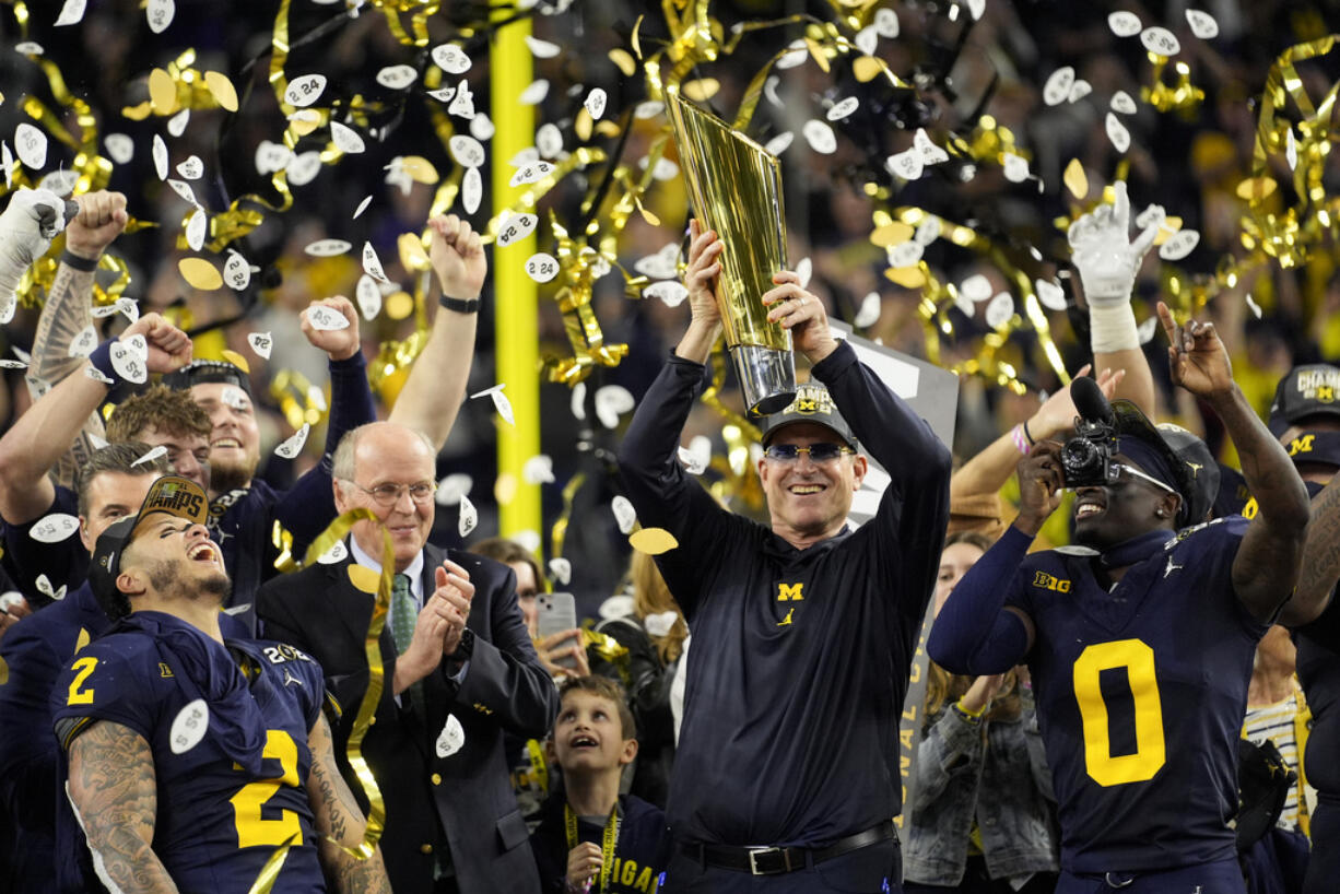 Michigan head coach Jim Harbaugh celebrates with the trophy after their win against Washington in the national championship NCAA College Football Playoff game Monday, Jan. 8, 2024, in Houston.