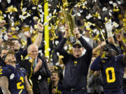 Michigan head coach Jim Harbaugh celebrates with the trophy after their win against Washington in the national championship NCAA College Football Playoff game Monday, Jan. 8, 2024, in Houston.