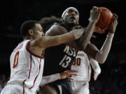 Southern California guard Kobe Johnson (0) fouls Washington State forward Isaac Jones (13) during the second half of an NCAA college basketball game in Los Angeles, Wednesday, Jan. 10, 2024.
