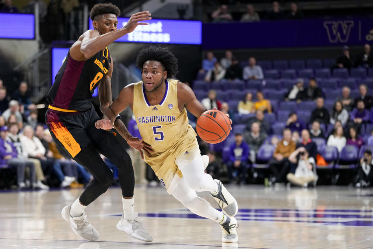 Washington guard Sahvir Wheeler (5) drives against Arizona State forward Alonzo Gaffney (8) during the first half of an NCAA college basketball game Thursday, Jan. 11, 2024, in Seattle.