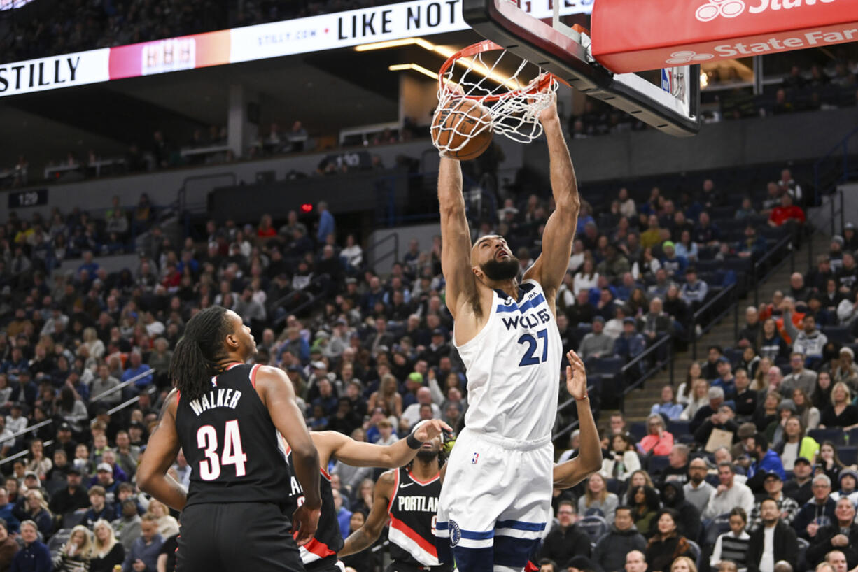 Minnesota Timberwolves center Rudy Gobert (27) dunks as Portland Trail Blazers forward Jabari Walker (34) watches during the first half of an NBA basketball game Friday, Jan. 12, 2024, in Minneapolis.