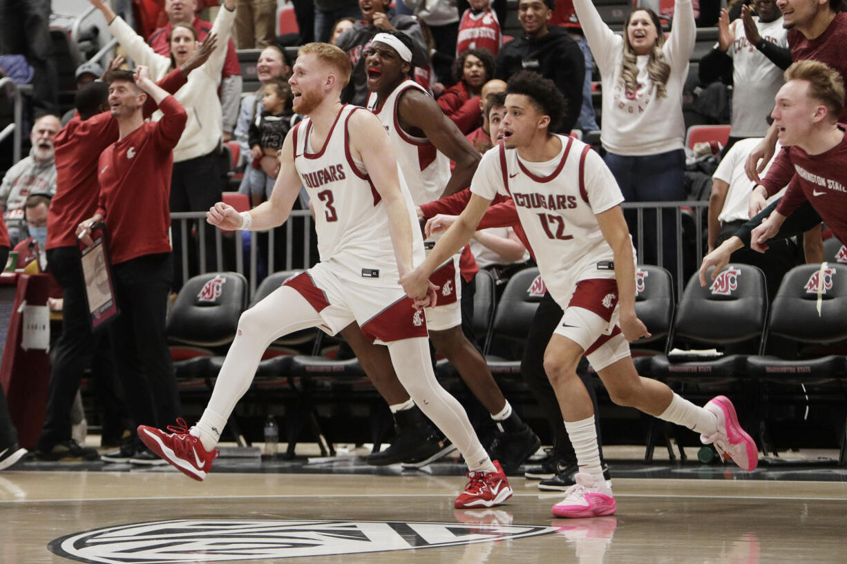 Washington State guards Jabe Mullins (3), Isaiah Watts (12) and teammates celebrate after their win over Arizona in an NCAA college basketball game, Saturday, Jan. 13, 2024, in Pullman, Wash.