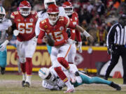 Kansas City Chiefs quarterback Patrick Mahomes (15) runs in front of Miami Dolphins defensive end Emmanuel Ogbah (91) during the first half of an NFL wild-card playoff football game Saturday, Jan. 13, 2024, in Kansas City, Mo.