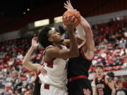 Washington State forward Isaac Jones, left, drives to the basket against Utah forward Ben Carlson during the second half of an NCAA college basketball game Wednesday, Jan. 24, 2024, in Pullman, Wash.