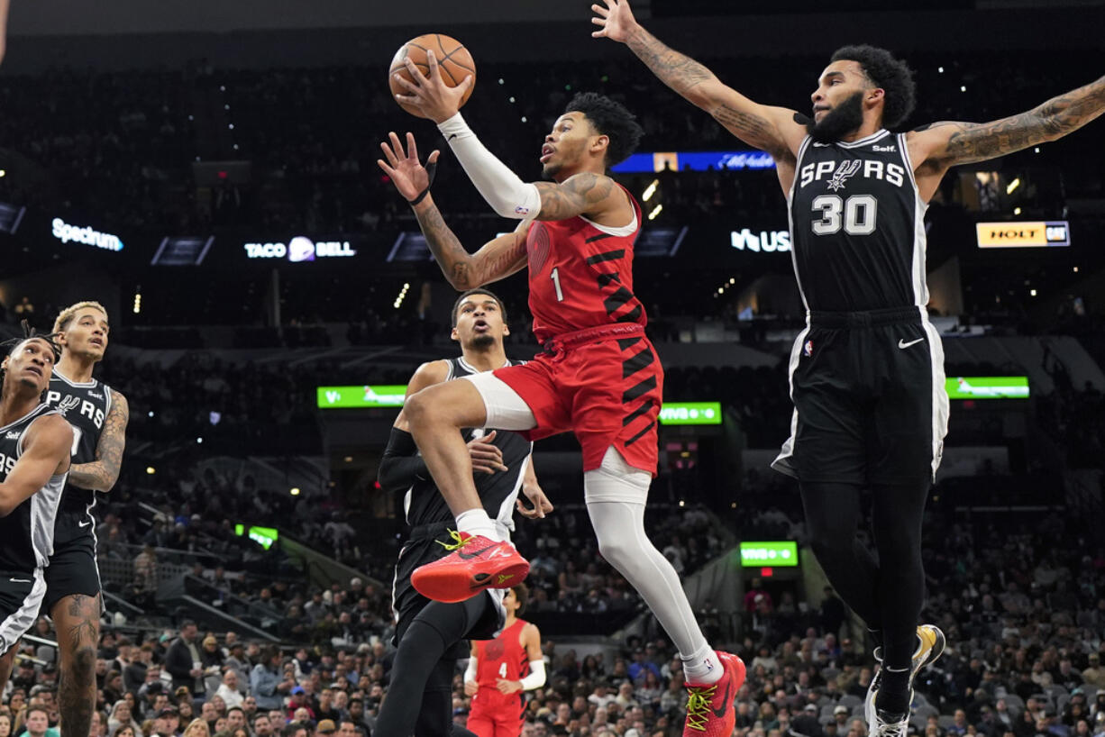 Portland Trail Blazers guard Anfernee Simons (1) drives to the basket past San Antonio Spurs forward Julian Champagnie (30) during the first half of an NBA basketball game in San Antonio, Friday, Jan. 26, 2024.