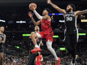 Portland Trail Blazers guard Anfernee Simons (1) drives to the basket past San Antonio Spurs forward Julian Champagnie (30) during the first half of an NBA basketball game in San Antonio, Friday, Jan. 26, 2024.