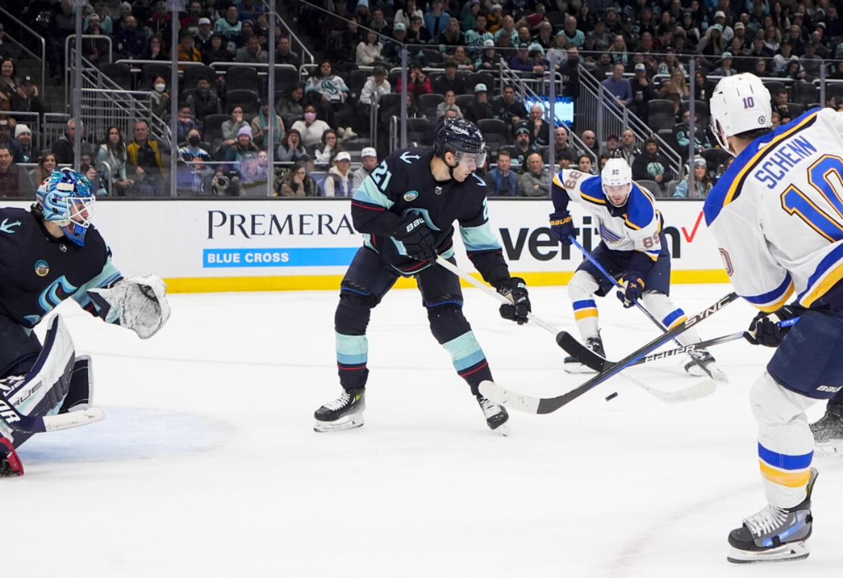 St. Louis Blues left wing Pavel Buchnevich, second from right, gets the pass from center Brayden Schenn (10) before scoring against Seattle Kraken center Alex Wennberg (21) and goaltender Joey Daccord, left, during overtime in an NHL hockey game Friday, Jan. 26, 2024, in Seattle.