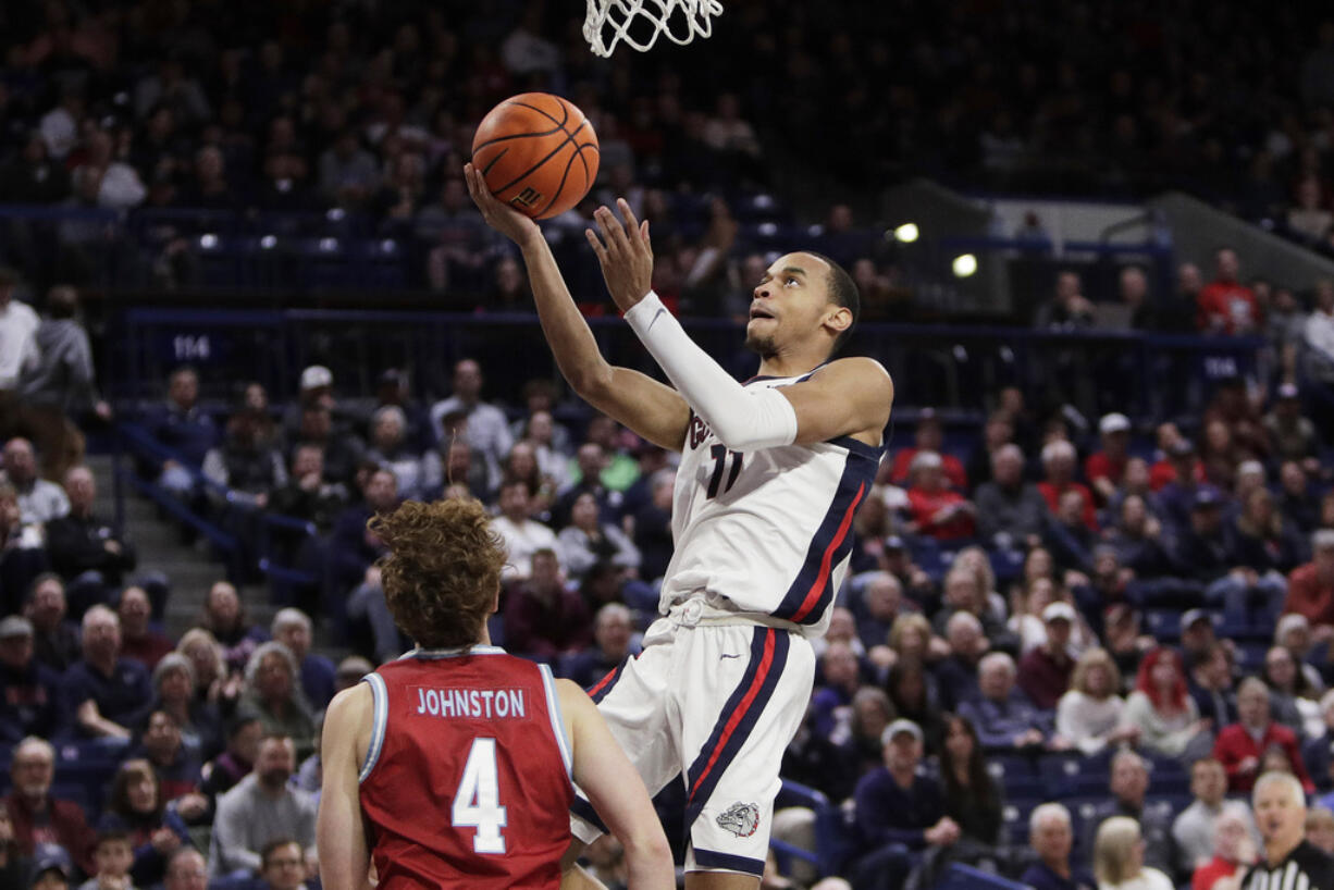 Gonzaga guard Nolan Hickman (11) shoots next to Loyola Marymount guard Will Johnston (4) during the second half of an NCAA college basketball game, Tuesday, Jan. 30, 2024, in Spokane, Wash.