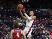 Gonzaga guard Nolan Hickman (11) shoots next to Loyola Marymount guard Will Johnston (4) during the second half of an NCAA college basketball game, Tuesday, Jan. 30, 2024, in Spokane, Wash.