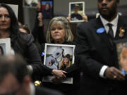 People hold photos of their loved ones as they sit in the audience before the start of a Senate Judiciary Committee hearing with the heads of social media platforms on Capitol Hill in Washington, Wednesday, Jan. 31, 2024, to discuss child safety.