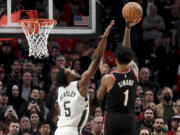 Portland Trail Blazers guard Anfernee Simons (1) hits a shot over Milwaukee Bucks guard Malik Beasley (5) late in the second half of an NBA basketball game in Portland, Ore., Wednesday, Jan. 31, 2024.