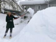 Tamera Flores shovels snow off her driveway, Monday, Jan. 29, 2024, in Anchorage Alaska.