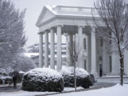 A worker removes snow from the White House driveway during a winter storm, Friday, Jan. 19, 2024, in Washington.