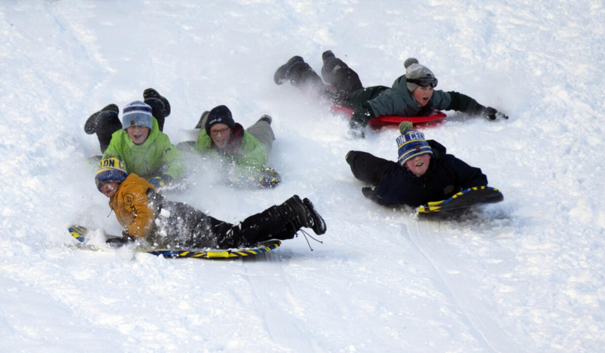 Youths slide on snow at Pippy Park in St. John&#039;s, Newfoundland and Labrador, Canada, on Saturday, Jan. 6, 2024, following the first significant snow storm of the winter.