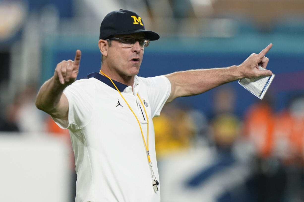 FILE - Michigan coach Jim Harbaugh gestures during warmups before the team&#039;s Orange Bowl NCAA college football playoff semifinal against Georgia, Dec. 31, 2021, in Miami Gardens, Fla. Harbaugh will be the coach of the Los Angeles Chargers, leaving Michigan after capping his ninth season as coach of college football&rsquo;s winningest program with the school&rsquo;s first national championship since 1997, two people familiar with the situation told The Associated Press. The people spoke to the AP on condition of anonymity because the team hasn&rsquo;t made the announcement.