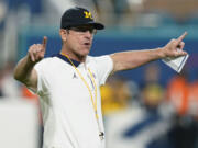 FILE - Michigan coach Jim Harbaugh gestures during warmups before the team&#039;s Orange Bowl NCAA college football playoff semifinal against Georgia, Dec. 31, 2021, in Miami Gardens, Fla. Harbaugh will be the coach of the Los Angeles Chargers, leaving Michigan after capping his ninth season as coach of college football&rsquo;s winningest program with the school&rsquo;s first national championship since 1997, two people familiar with the situation told The Associated Press. The people spoke to the AP on condition of anonymity because the team hasn&rsquo;t made the announcement.
