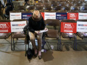 Sandra Sandfort, of Ames, Iowa, signs a commit to caucus card before a Republican presidential candidate Nikki Haley town hall, Monday, Dec. 18, 2023, in Nevada, Iowa.