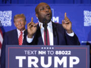 FILE - Republican presidential candidate former President Donald Trump, left, listens as Sen. Tim Scott, R-S.C., speaks at a campaign event in Concord, N.H., Jan. 19, 2024. Black voters support the reelection of President Joe Biden at a surprisingly low level, according to recent AP polling. For Republican strategists and former President Donald Trump, that&rsquo;s an opportunity to make inroads into the Democratic Party&rsquo;s most loyal voting bloc. Both parties are fine-tuning efforts to win over Black voters. Scott, who once challenged Trump for the GOP nomination, has emerged as one of his most prominent surrogates and speaks often about his record on race.