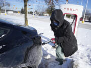 Ankita Bansal prepares to charge her Tesla, Wednesday, Jan. 17, 2024, in Ann Arbor, Mich. A subzero cold snap across the nation has exposed a big vulnerability for electric vehicle owners. It&rsquo;s difficult to charge the batteries in single-digit temperatures.