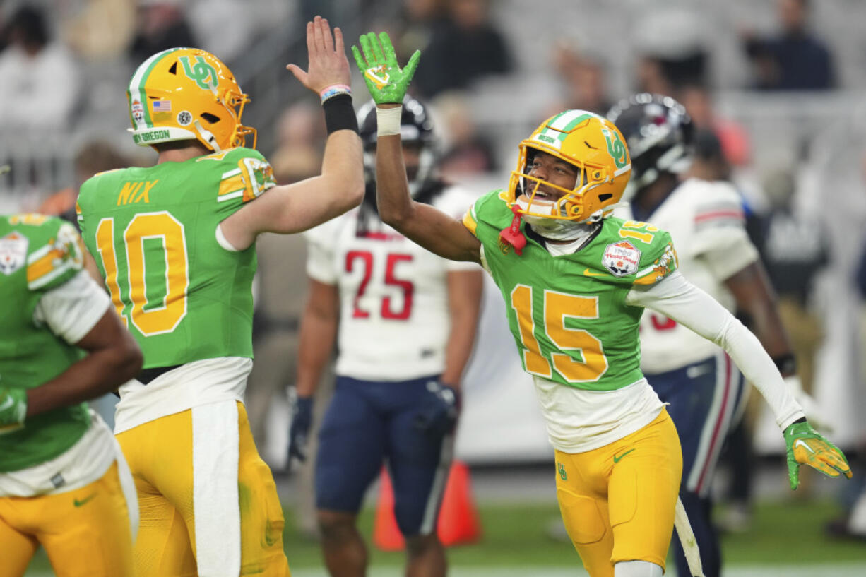 Oregon wide receiver Tez Johnson (15) celebrates his touchdown with quarterback Bo Nix (10) during the second half on the NCAA Fiesta Bowl college football game against Liberty, Monday, Jan. 1, 2024, in Glendale, Ariz. Oregon defeated Liberty 45-6. (AP Photo/Ross D.