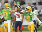 Oregon wide receiver Tez Johnson (15) celebrates his touchdown with quarterback Bo Nix (10) during the second half on the NCAA Fiesta Bowl college football game against Liberty, Monday, Jan. 1, 2024, in Glendale, Ariz. Oregon defeated Liberty 45-6. (AP Photo/Ross D.