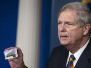 FILE - Agriculture Secretary Tom Vilsack holds up a Supplemental Nutrition Assistance Program Electronic Benefits Transfer (SNAP EBT) card during a news conference at the White House, Wednesday, May 5, 2021, in Washington. Nearly 21 million children in the U.S. and its territories are expected to receive food benefits this summer through a newly permanent federal program, the United States Department of Agriculture announced Wednesday, Jan. 10, 2024. &ldquo;No child in this country should go hungry,&rdquo; Vilsack said in an interview on Tuesday.