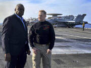 Defense Secretary Lloyd Austin, left, talks with the commanding officer of the USS Gerald R. Ford, Navy Capt. Rick Burgess, during an unannounced visit to the ship on Wednesday, Dec. 20, 2023. The USS Gerald R. Ford has been sailing just a few hundred miles off the coast of Israel to prevent the Israel-Hamas war from expanding into a regional conflict.