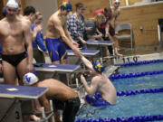 Harry Eugenis of Kelso is helped out of the pool after swimming the anchor leg in Kelso's win in the 200 freestyle relay at the Kelso Invitational swim meet at Kelso High School on Saturday, January 20, 2024.