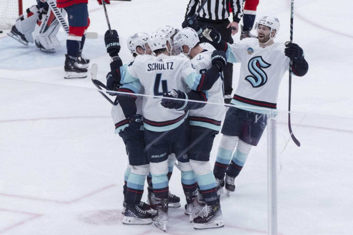 Seattle Kraken defenseman Justin Schultz (4) is congratulated for a goal against the Washington Capitals during the second period of an NHL hockey game Thursday, Jan. 11, 2024, in Washington.