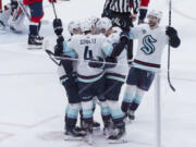 Seattle Kraken defenseman Justin Schultz (4) is congratulated for a goal against the Washington Capitals during the second period of an NHL hockey game Thursday, Jan. 11, 2024, in Washington.
