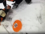 In this image taken from video provided by Michigan State Police, officers work to extricate a man from the waters of frozen Arbutus Lake in Grand Traverse County, Mich., Thursday, Jan. 18, 2024. The man was rescued after a quick-thinking state police officer used the stranded man&rsquo;s dog to get rescue equipment to him and pull the man to safety in a rescue captured on video.